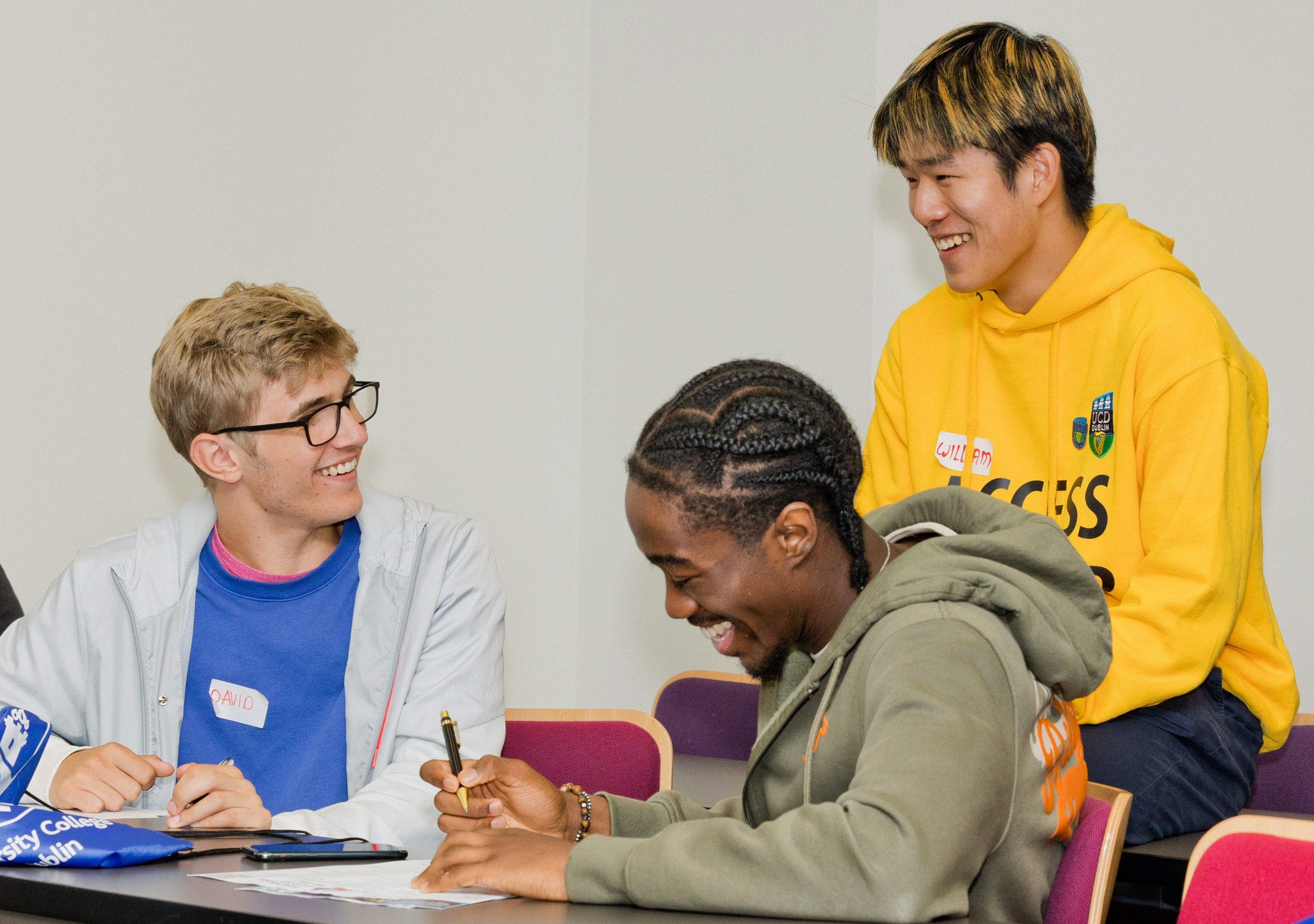 A UCD access leader talking to two students.