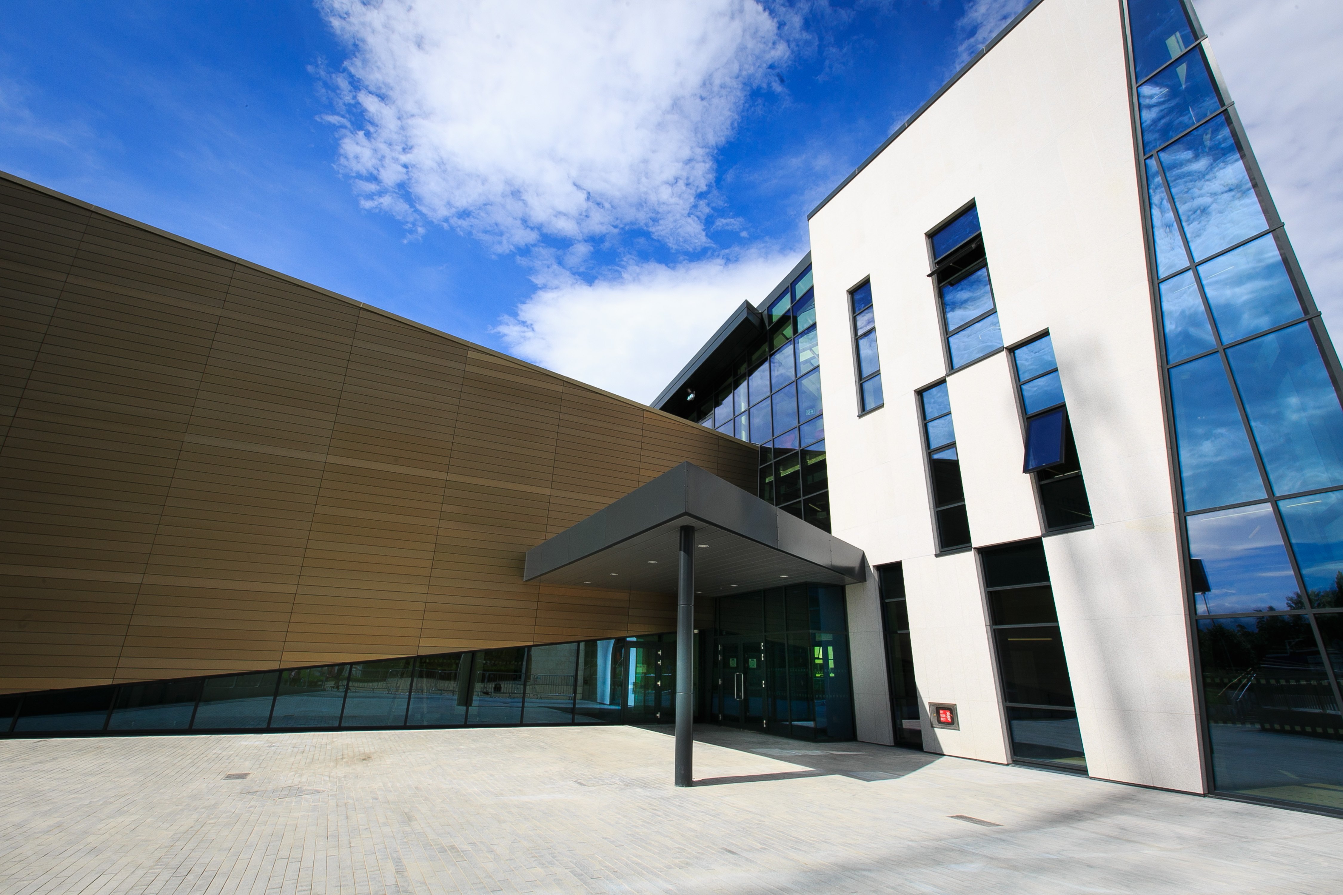 A white building with dark rectangular windows and a small porch