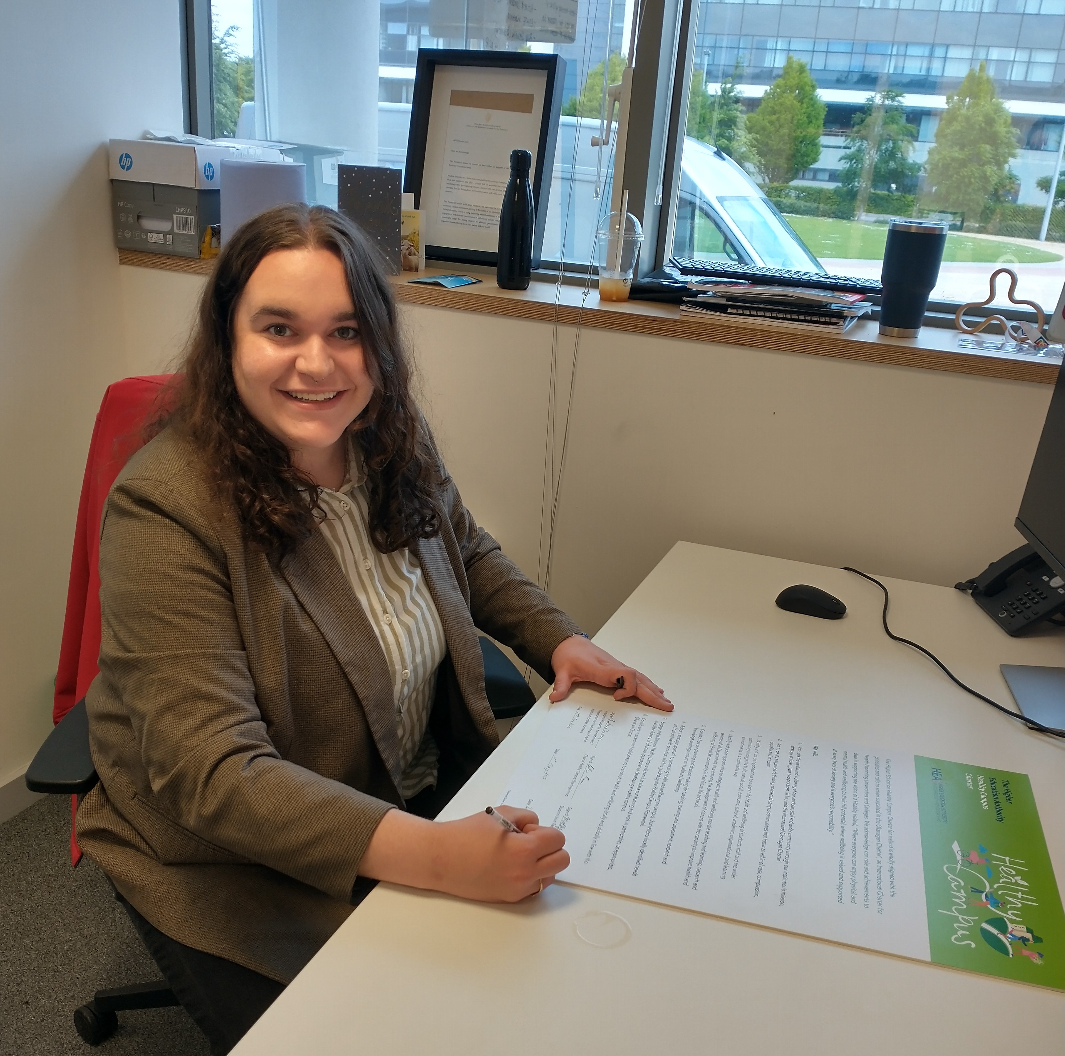 Molly Greenough, UCDSU President, signs the HEA Healthy Campus Charter