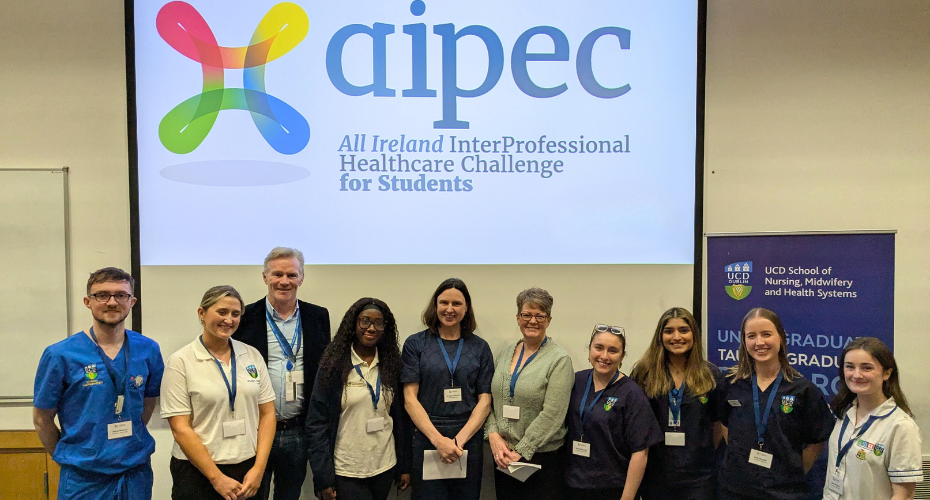 A group of people standing together smiling in front of a projector screen