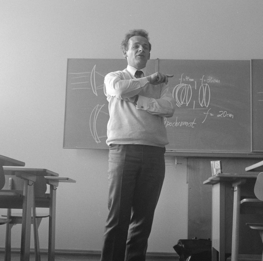 A black and white image of a professor addressing his class