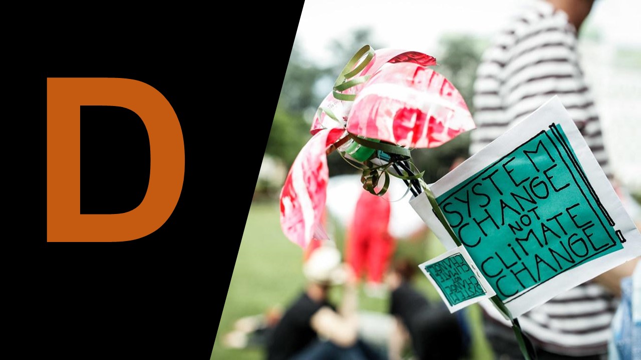 Sign carried by protester reading 'System change not climate change', large capital D