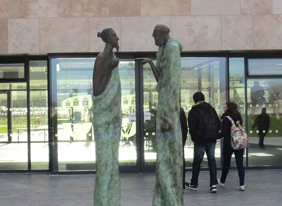 Tall statues one pointing at the other