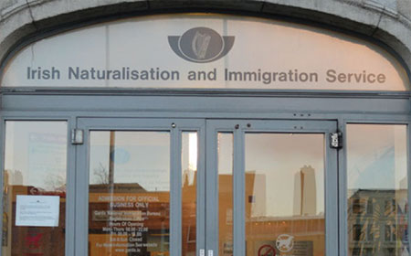 A glass door that leads into a the Irish Naturalisation and Immigration Services office.