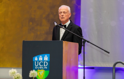 Prof Michael Keane standing at podium delivering speech during 2025 graduation dinner