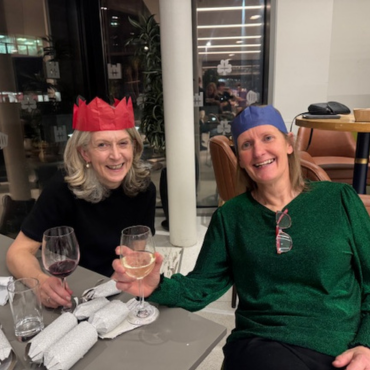 Two women in party hats at the UCD Physiotherapy 70th anniversary celebration