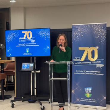Woman in a green top speaking at the UCD Physiotherapy 70th anniversary celebration