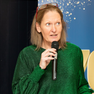 Woman in green top speaking at the UCD Physiotherapy 70th anniversary celebration