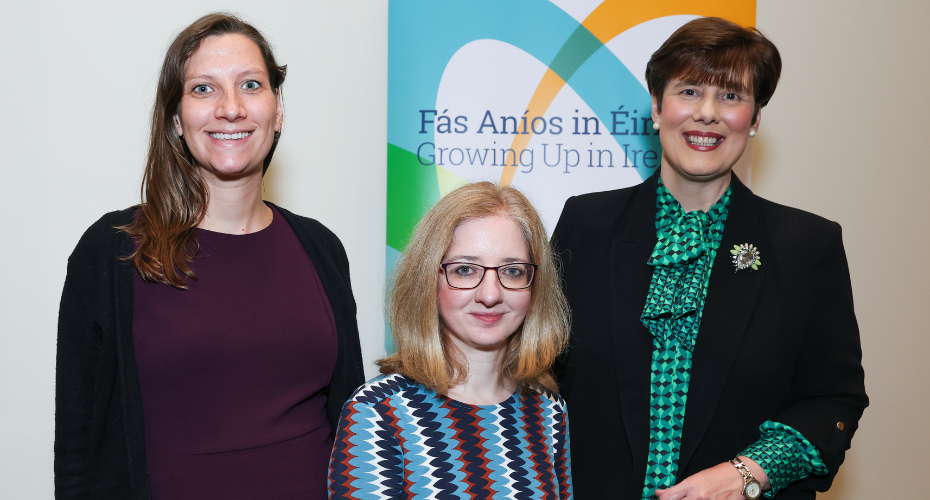 Three women standing in front of a Growing up in Ireland stand
