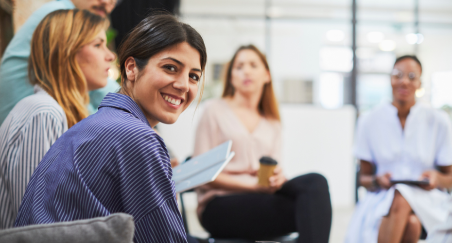 Young person working with a group of others in an office