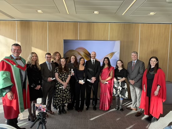 Group photograph of people wearing degree conferring robes