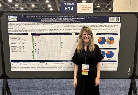 female student standing in front of research poster