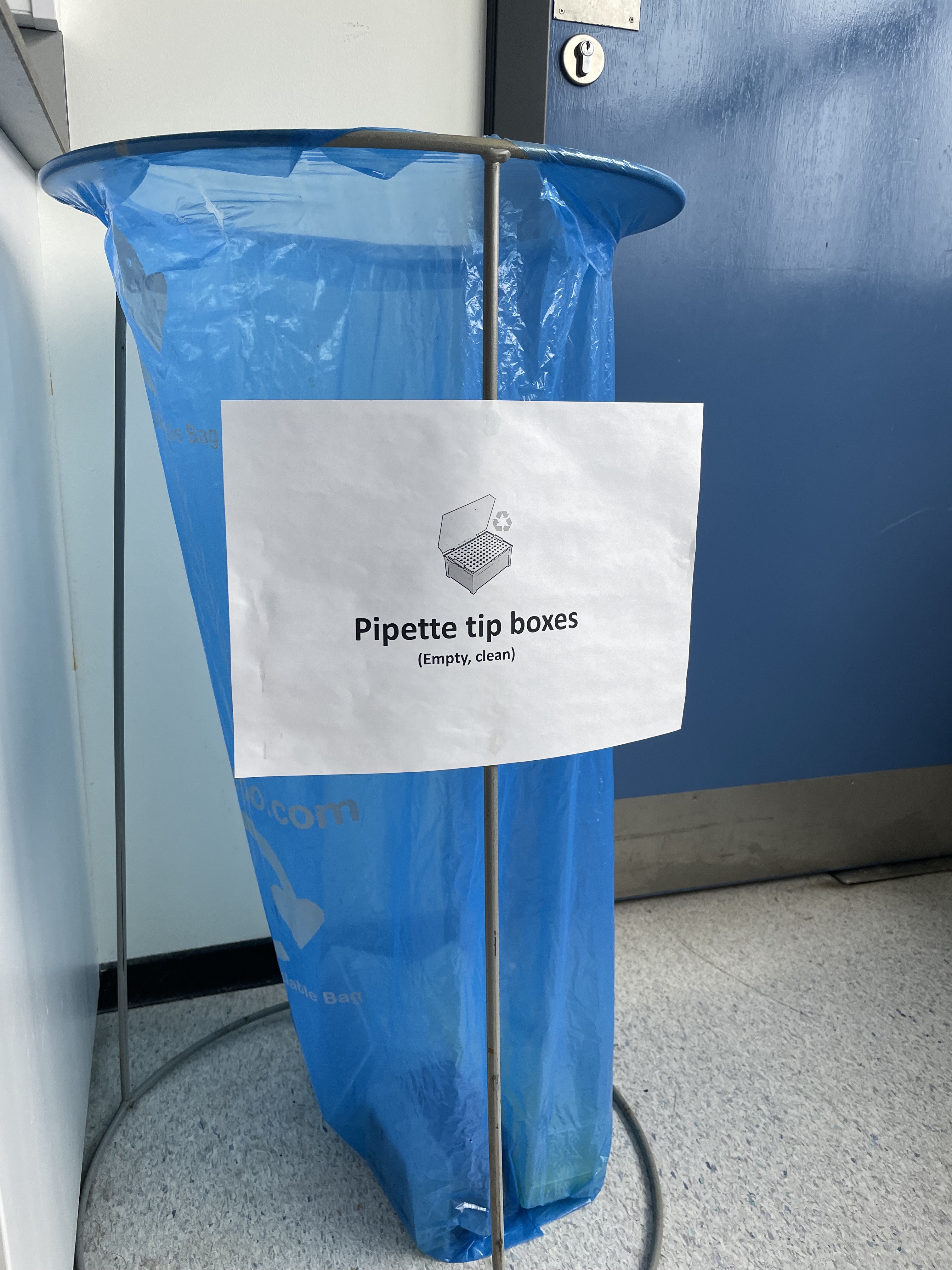 Blue bagged bin with sign for pipette tip box recycling
