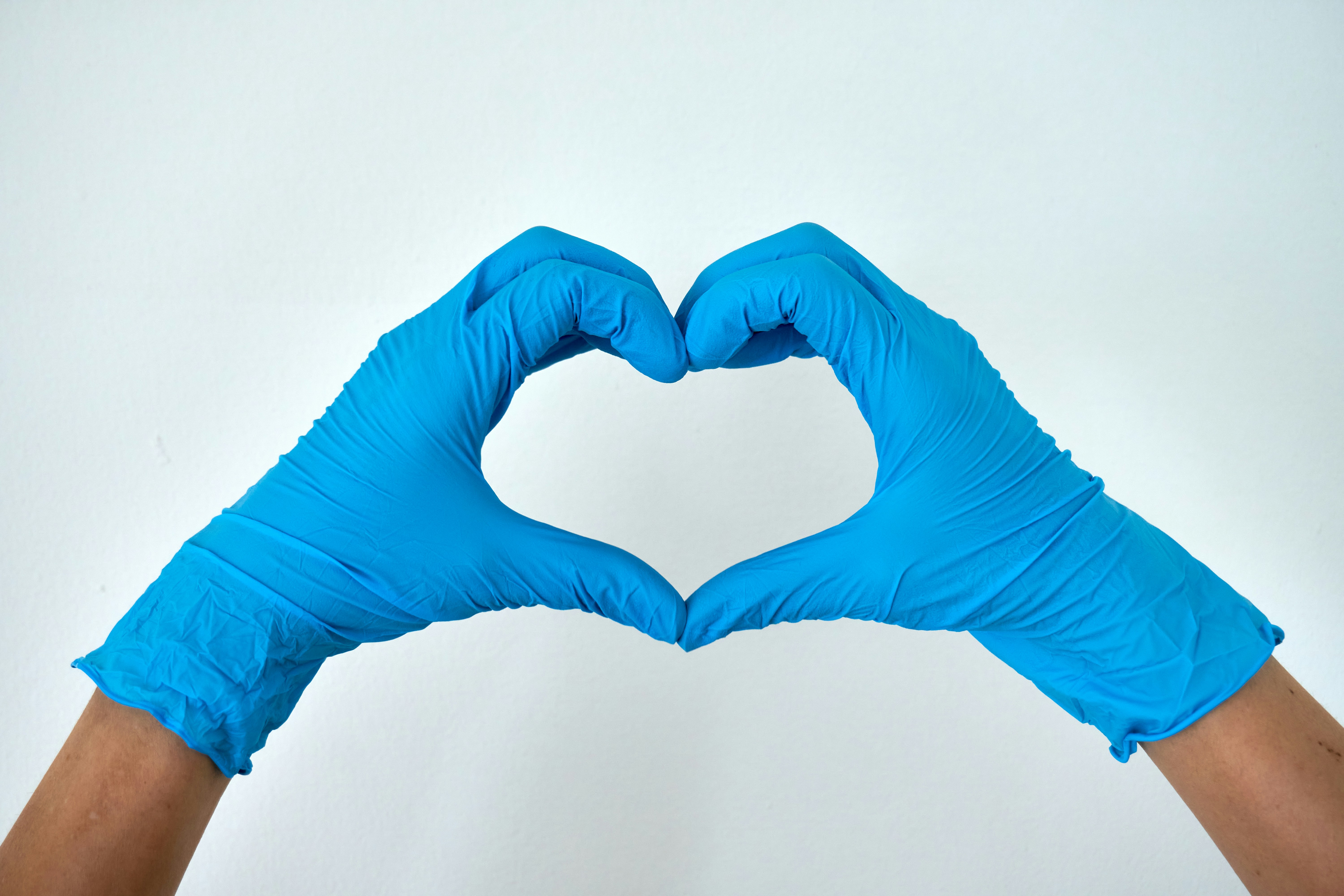 Blue gloved hands making a heart shape