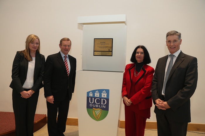 People standing beside placque