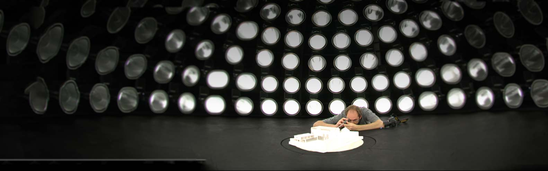 A photographer lying on the ground to shoot an architectural model
